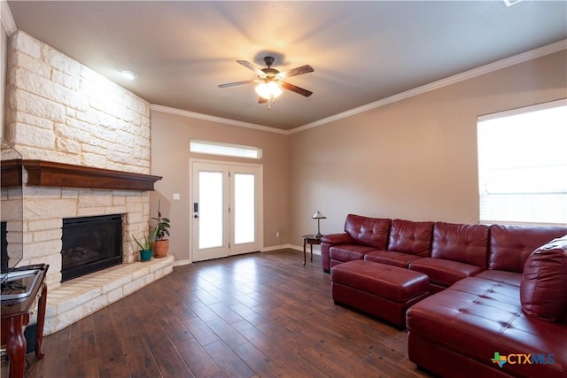 living room featuring ceiling fan, dark hardwood / wood-style floors, ornamental molding, and a stone fireplace