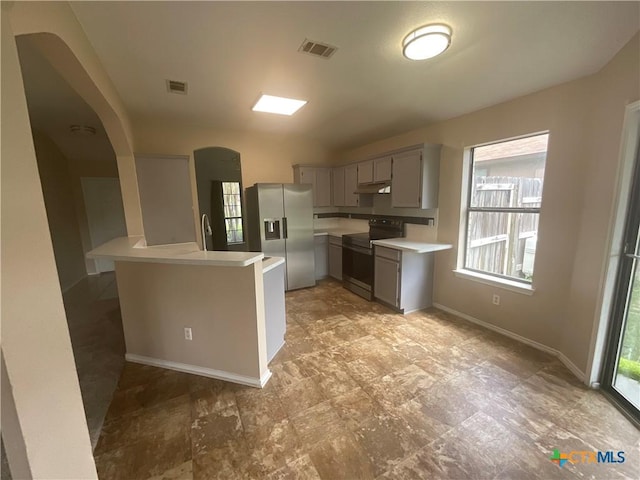 4607 Stanford Dr, Killeen, TX 76542 - kitchen featuring appliances with stainless steel finishes, light countertops, under cabinet range hood, gray cabinets, and arched walkways