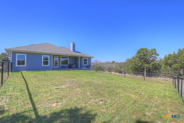 315 Hilltop Rdg, New Braunfels, TX 78132 - back of house with a fenced backyard, a lawn, and a chimney