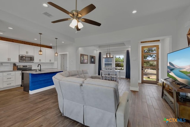 315 Hilltop Rdg, New Braunfels, TX 78132 - living area featuring recessed lighting, visible vents, ceiling fan with notable chandelier, and dark wood-style floors