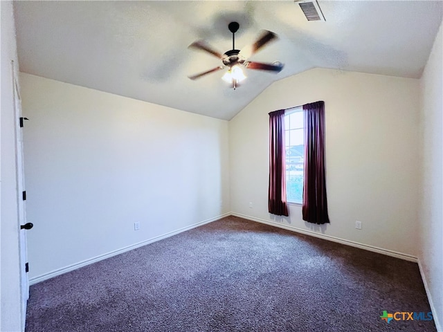 empty room with ceiling fan, vaulted ceiling, and dark carpet