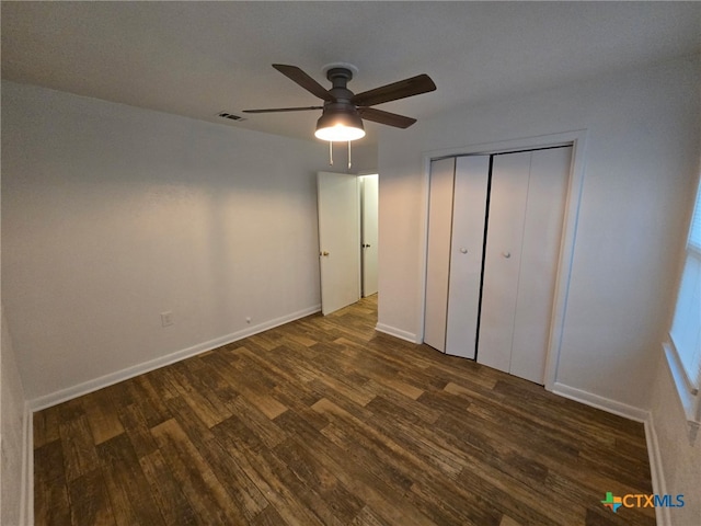unfurnished bedroom featuring visible vents, a closet, baseboards, ceiling fan, and dark wood-type flooring