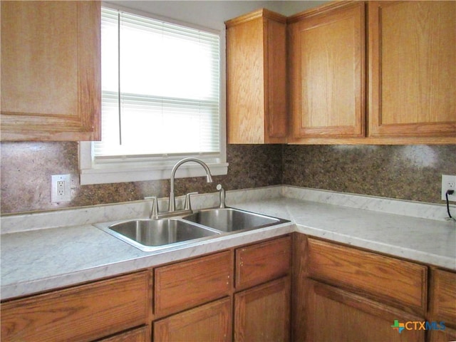 kitchen with brown cabinets, a sink, and light countertops
