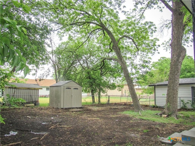 view of yard featuring an outdoor structure, fence, and a shed