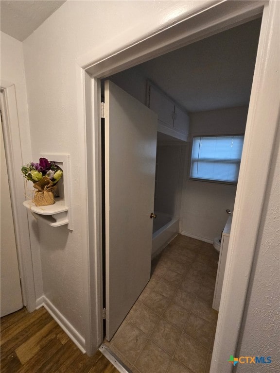 full bath with toilet and baseboards