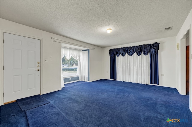 carpeted entryway with a textured ceiling