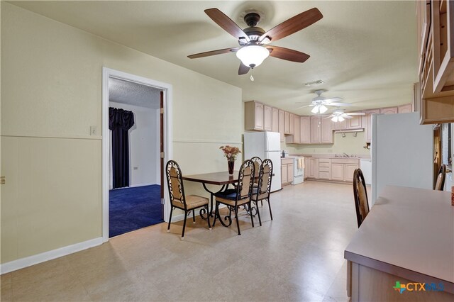 dining room featuring ceiling fan, a textured ceiling, and sink