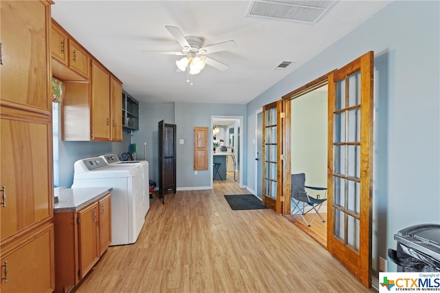 clothes washing area featuring cabinets, light hardwood / wood-style floors, separate washer and dryer, ceiling fan, and french doors