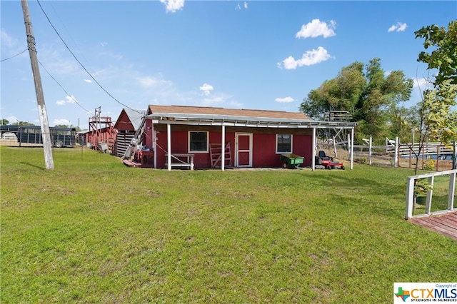 back of house featuring an outbuilding and a yard