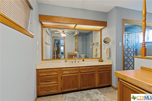 bathroom featuring a shower with shower curtain, ceiling fan, and vanity