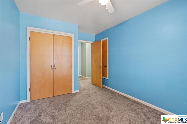 unfurnished bedroom featuring ceiling fan, a closet, and light colored carpet