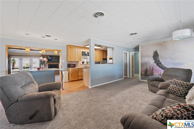 living room featuring light carpet and french doors