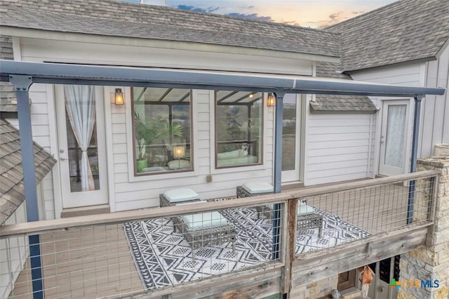 exterior space featuring roof with shingles