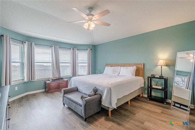 bedroom with ceiling fan, baseboards, and wood finished floors