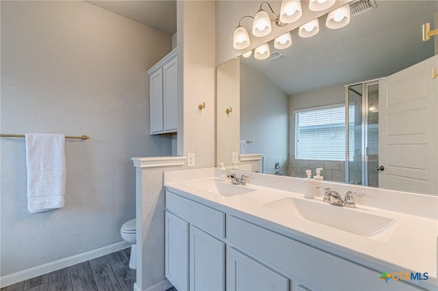 bathroom with a sink, visible vents, toilet, and a stall shower