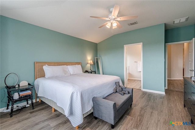 bedroom featuring lofted ceiling, wood finished floors, and visible vents