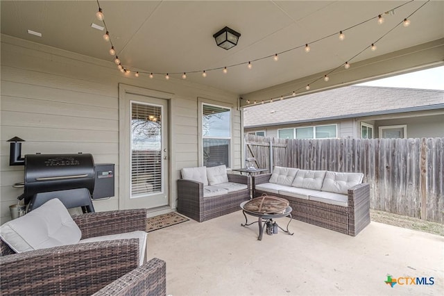 view of patio featuring an outdoor living space with a fire pit and fence