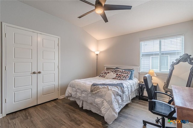 bedroom featuring a ceiling fan, wood finished floors, baseboards, vaulted ceiling, and a closet