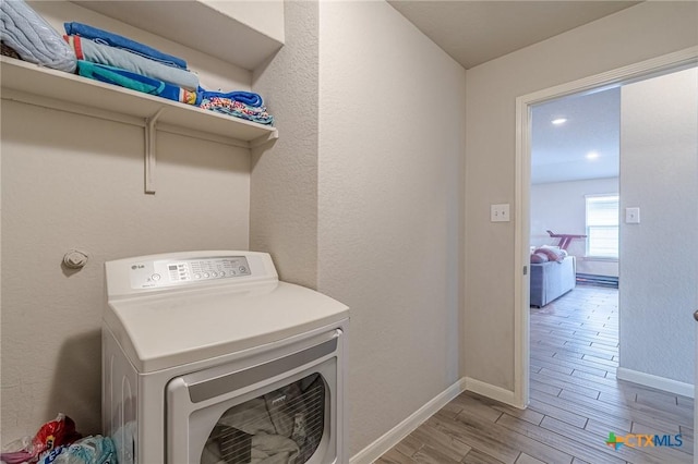 laundry area featuring laundry area, washer / clothes dryer, baseboards, and wood finished floors