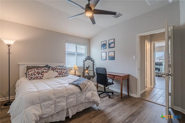 bedroom featuring visible vents, wood finished floors, baseboards, lofted ceiling, and ceiling fan