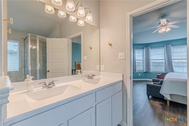 full bath with connected bathroom, a shower stall, ceiling fan, double vanity, and a sink