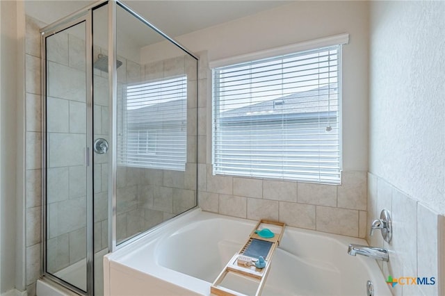 full bathroom featuring a garden tub and a shower stall