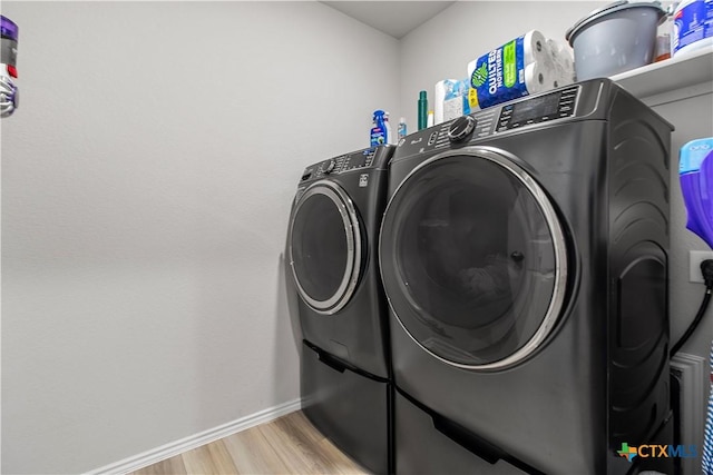 washroom featuring light hardwood / wood-style floors and washer and clothes dryer