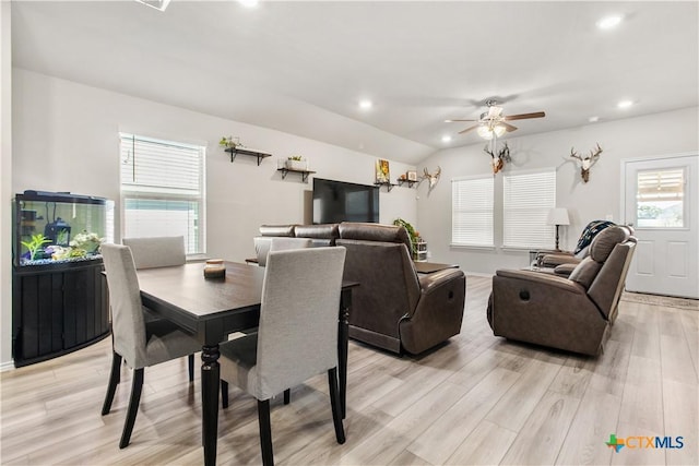 dining space with ceiling fan, plenty of natural light, light wood-type flooring, and lofted ceiling