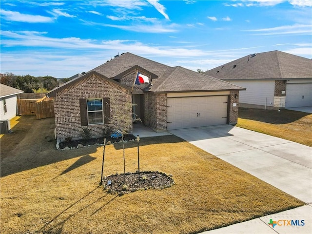 single story home with a garage, a front lawn, and central air condition unit