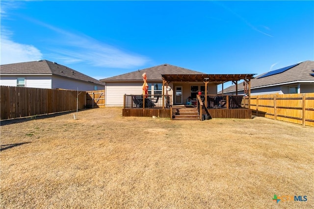 rear view of property featuring a wooden deck, a lawn, and a pergola