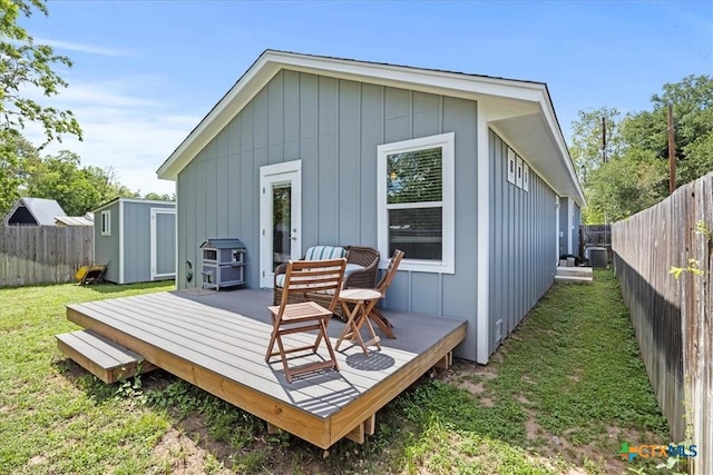 458 Seele St, New Braunfels, TX 78130 - rear view of property with board and batten siding, a deck, an outbuilding, cooling unit, and a storage unit