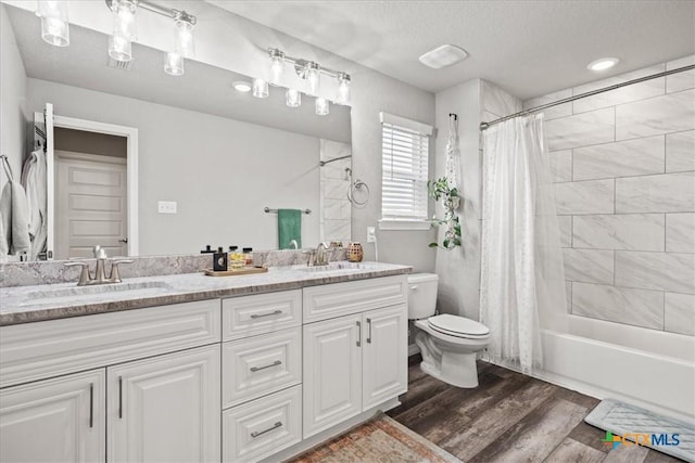 458 Seele St, New Braunfels, TX 78130 - bathroom with toilet, wood finished floors, shower / bath combo, double vanity, and a textured ceiling