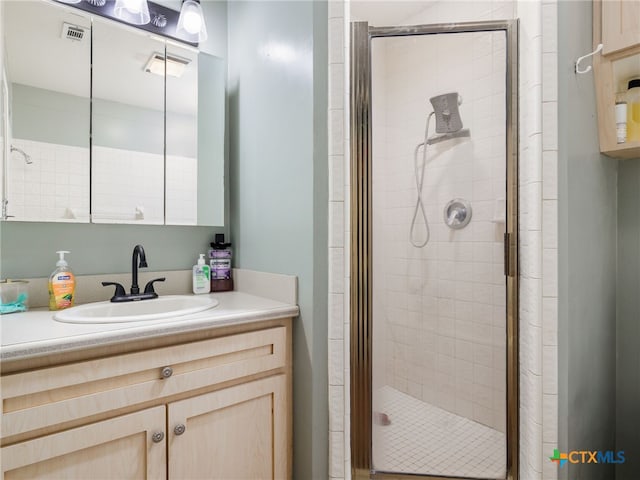 bathroom with a stall shower, visible vents, and vanity