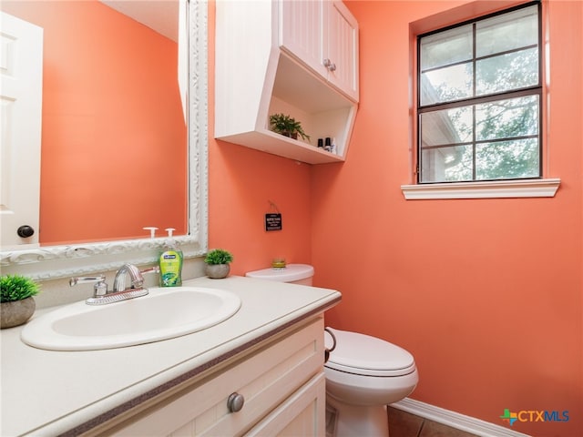 bathroom with tile patterned flooring, vanity, and toilet