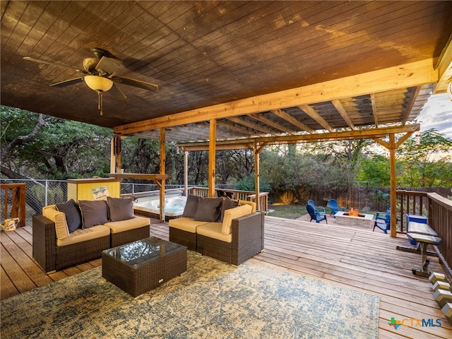 wooden deck with fence, a ceiling fan, and an outdoor living space with a fire pit