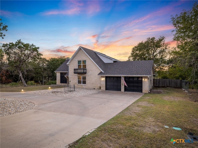 view of front of house with an attached garage, concrete driveway, a front yard, and fence