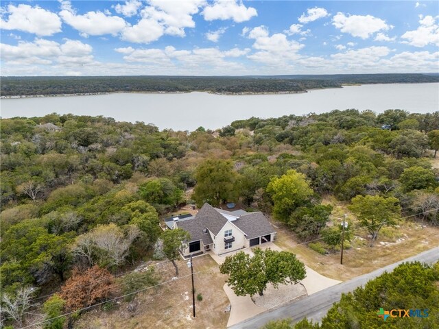 drone / aerial view with a water view and a forest view