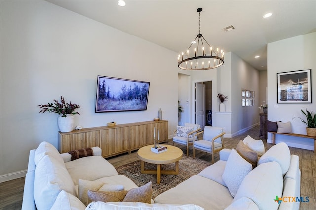 living room featuring dark wood-type flooring and a notable chandelier