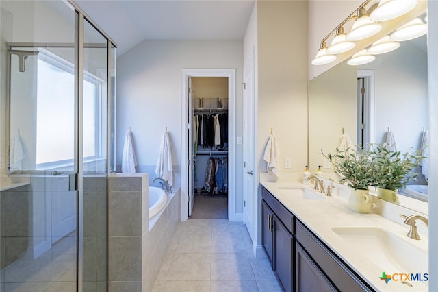 bathroom with vanity, a healthy amount of sunlight, tile patterned floors, and lofted ceiling