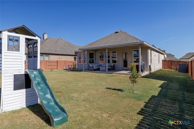 back of house with an outdoor living space, a playground, and a yard