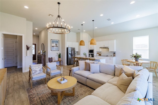 living room featuring a notable chandelier and light hardwood / wood-style floors