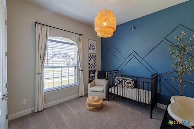 bedroom featuring a crib, multiple windows, and carpet