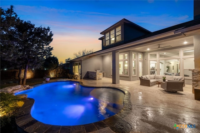 pool at dusk with ceiling fan, a patio, a fenced in pool, and an outdoor hangout area