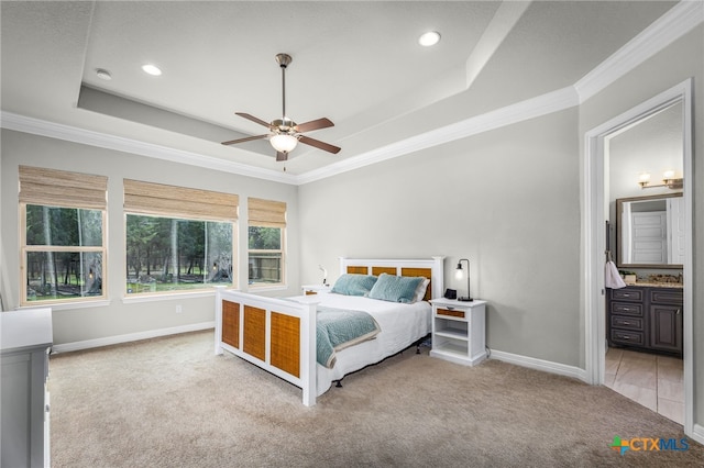 unfurnished bedroom with baseboards, a raised ceiling, light carpet, and ornamental molding