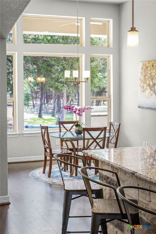 dining room featuring a notable chandelier and baseboards