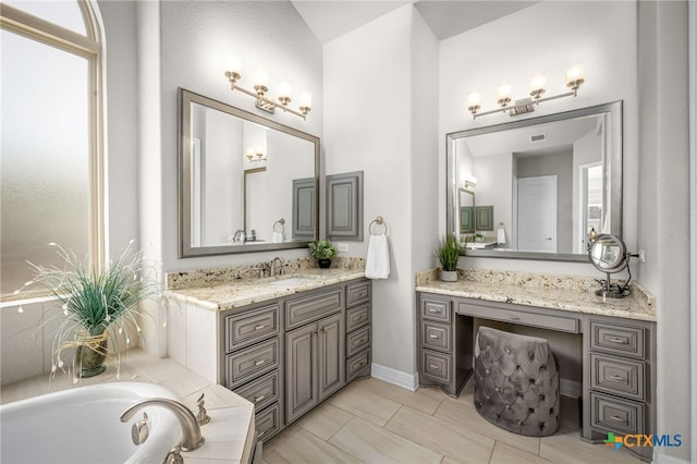 full bath featuring vanity, a bath, and visible vents