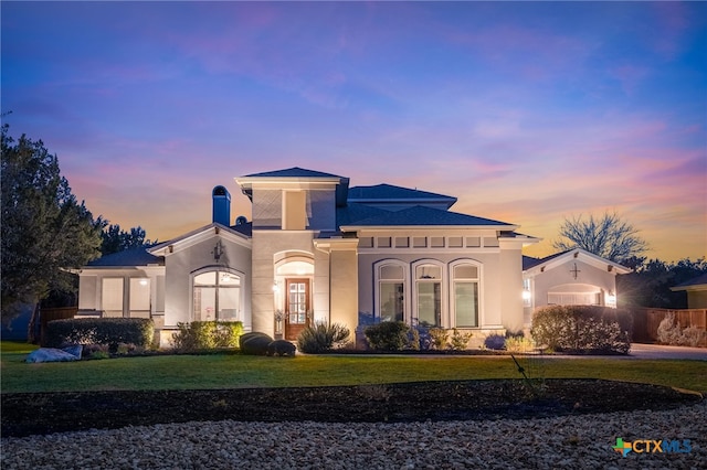 mediterranean / spanish-style home featuring a lawn, french doors, and stucco siding