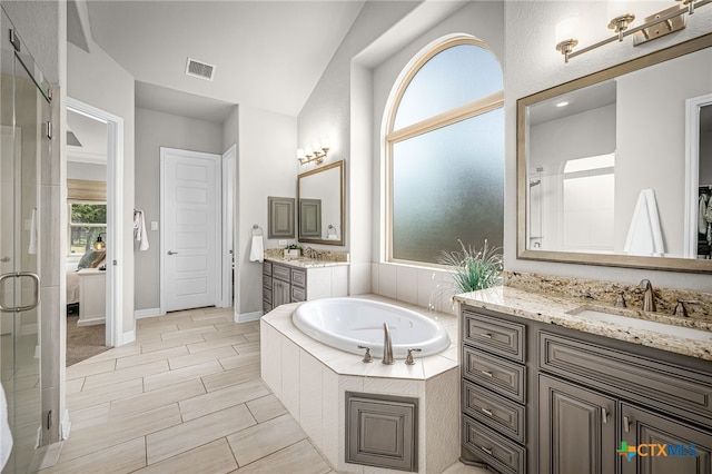 ensuite bathroom with a shower with door, visible vents, connected bathroom, a garden tub, and a sink