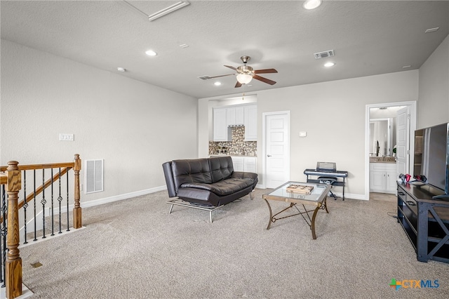 living room featuring recessed lighting, light colored carpet, visible vents, and baseboards