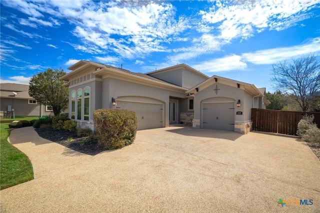 single story home featuring fence, driveway, stucco siding, a garage, and stone siding